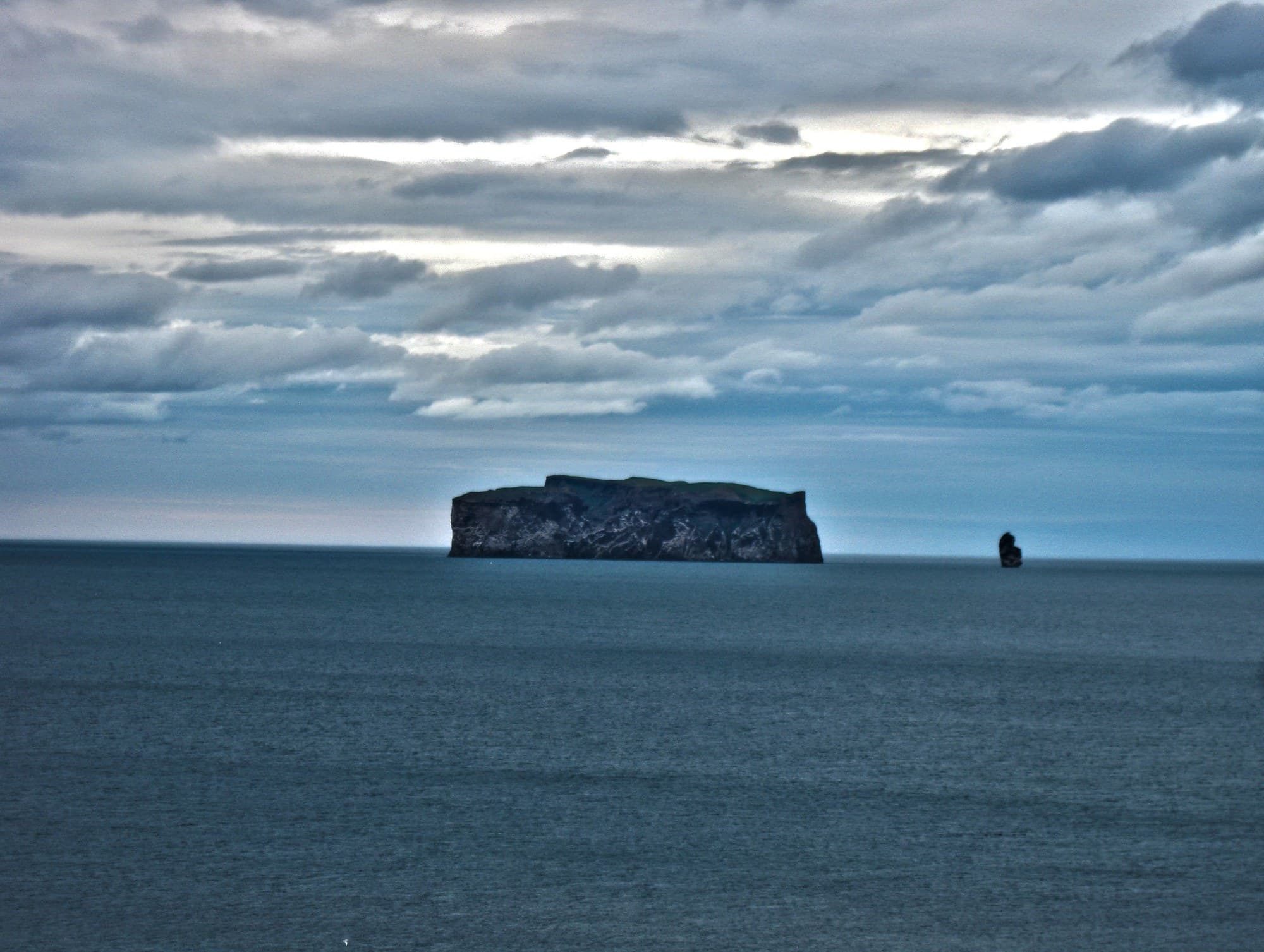 Drangey, a cliff-sided island, standing in Skagafjörður, Iceland, under heavy cloud.